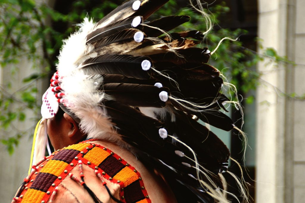 Rear portrait of native American Indian chief with headdress of feathers